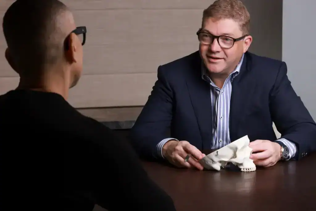 Neurosurgeon discussing cerebrovascular surgery options with patient.